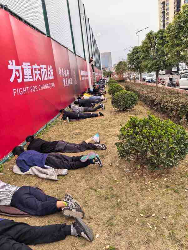 接地气,重庆球迷趴在草地上透过围栏缝隙观看铜梁龙热身赛 新闻